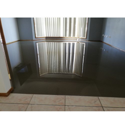 A room with a standing self-levelling compound covering the floor, reflecting light and furniture.